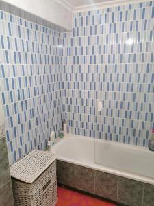 een blauwe betegelde badkamer met een bad en een tafel bij Apartamento vacacional en Brión, 15280 Río pego in Brion