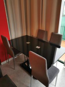 a black dining room table with chairs around it at Apartamento vacacional en Brión, 15280 Río pego in Brion