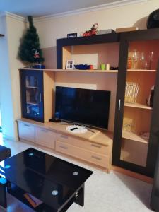 ein großes Entertainment-Center mit einem großen Flachbildfernseher in der Unterkunft Apartamento vacacional en Brión, 15280 Río pego in Brion