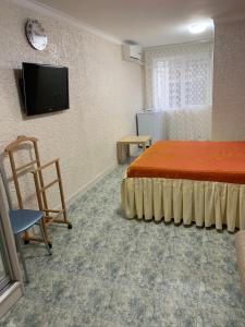 a room with a bed and a tv on a wall at Вита Гагра in Gagra