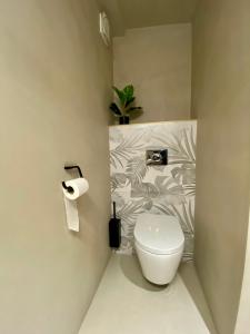 a bathroom with a toilet and a plant on the wall at LE STUDIO,Superbe appartement meublé avec terrasse in Foucherans +3 photos