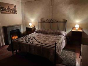 a bedroom with a bed and two lamps and a fireplace at Villa Terria in Bagni di Lucca