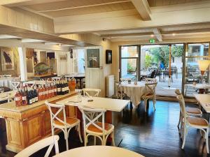 a dining room with tables and chairs and a restaurant at Hotel L'Océan in Le Bois-Plage-en-Ré