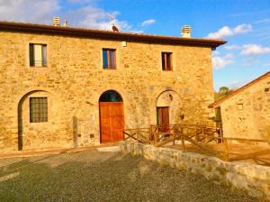 a large brick building with a wooden door at Laura Chianti Vacanze in Poggibonsi