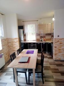 a kitchen with a wooden table and chairs at Domek letniskowy w lesie 6 -7 osób in Wydminy