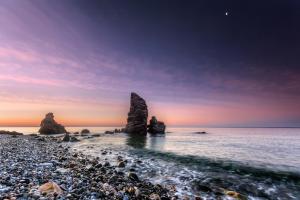 a rocky beach with two large rocks in the water at Apartamentos Balcón de Maro in Maro