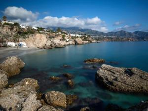 a view of a beach with rocks in the water at Apartamentos Balcón de Maro in Maro