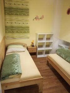 a bedroom with two beds and a shelf at Apartmán Orbit in Karlov