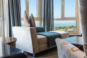 a living room with a couch and a large window at Le Royal Hotel in Kuwait