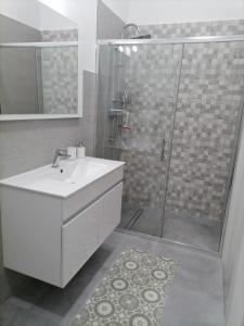 bagno con lavandino bianco e doccia di Darsena Apartments a Molfetta