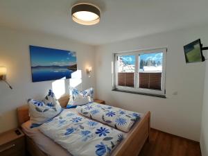 una camera da letto con un letto con cuscini blu e bianchi di Bergluft a Fügenberg