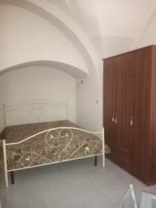 1 dormitorio con 1 cama y armario de madera en Monolocale Foggia Centro, en Foggia