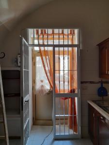 une porte ouverte menant à une cuisine avec un rideau orange dans l'établissement Monolocale Foggia Centro, à Foggia