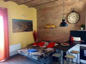 een kamer met een bed en een tafel en een klok bij Lovely & bright Vila Olimpica beach apartment in Barcelona