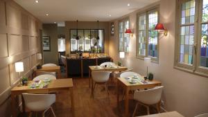 a restaurant with tables and chairs and a mirror at Hôtel Cardinal in Rouen