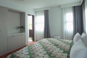 - une chambre avec un grand lit et une couette verte dans l'établissement Baanrincome, à Chiang Mai