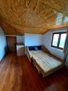Cama en habitación con techo de madera en Kuća na dan Vrla strana en Bosansko Petrovo Selo