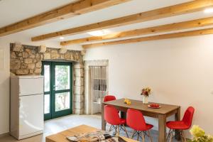 une cuisine et une salle à manger avec une table en bois et des chaises rouges dans l'établissement Holiday Home Anamarija, à Cavtat