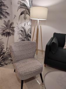 sala de estar con silla y lámpara en APARTAMENTO ROMAR CHIC, en Albolote
