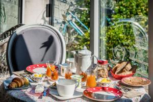 einen Tisch mit einem Frühstück mit Eierbrot und Orangensaft in der Unterkunft A La Lettre Thé in Molineuf