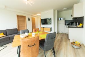 eine Küche und ein Wohnzimmer mit einem Holztisch und Stühlen in der Unterkunft Vis Saar Vie - Ferienwohnungen an der Saarschleife in Mettlach