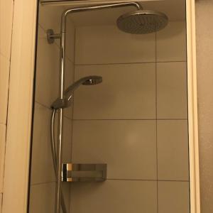 eine Dusche mit einer Glastür mit einem Duschkopf in der Unterkunft Petit Appart de Charme Eau chaude solaire Rénovation 2021 Wifi disponible Belvedere 5 in Saint-Luc