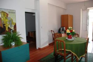 a living room with a table and a green table and chairs at Casa Galatea Etna nord via Bellini 141 Milo in Milo