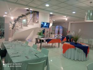 a dining room with tables and chairs and a staircase at Villa Imago in Roseto degli Abruzzi