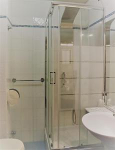 a bathroom with a shower and a toilet and a sink at Hotel Galant in Venaria Reale