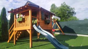 a playground with a slide and a play house at Drevenička Vodníček in Liptovský Trnovec