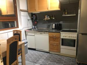 una piccola cucina con elettrodomestici bianchi e armadietti in legno di Unterkunft in Stuttgart a Stoccarda