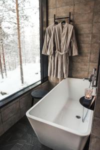 La salle de bains est pourvue d'une baignoire blanche et d'une fenêtre. dans l'établissement Kuru Resort, à Rantasalmi
