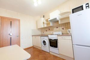 a kitchen with a washing machine and a refrigerator at Центр! Красноармейский 69б-13 in Barnaul