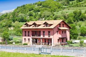 a house with a fence in front of a mountain at Hotel Rural El Fundil in El Pino