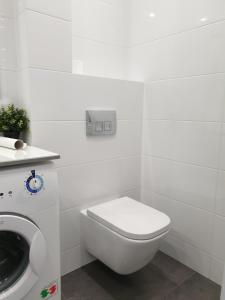 Un baño blanco con inodoro y lavabo. en Best Apartment Shevchenka 80, en Leópolis