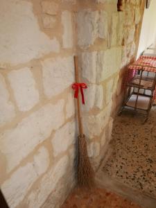 una escoba con un arco rojo en la pared en Cascina Tornara, ritorno alle origini monferrine, en Ozzano Monferrato