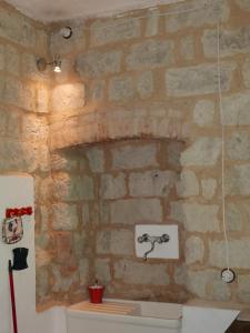 baño con pared de piedra y lavabo en Cascina Tornara, ritorno alle origini monferrine en Ozzano Monferrato