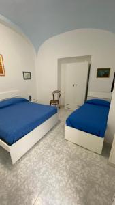 una camera con due letti con lenzuola blu di CASA ICARO ad Amalfi