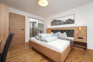 a bedroom with a large bed and a desk at Apart Sunnhäusl in Sölden