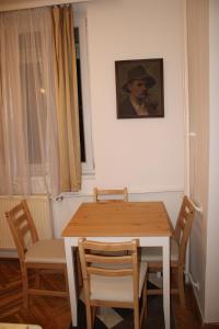 einen Esstisch und Stühle mit einem Bild an der Wand in der Unterkunft 3 hippos apartman in Budapest