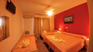 ein Hotelzimmer mit 2 Betten und roten Wänden in der Unterkunft Gran Lourdes Hotel by CPH in Villa Carlos Paz