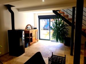 ein Wohnzimmer mit einer Treppe und einer Tür mit einer Pflanze in der Unterkunft Gîte La Glycine in Dun