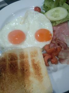 a plate with two eggs and a piece of toast at Cessna Park Resort and Hotel in Ban Hua Na