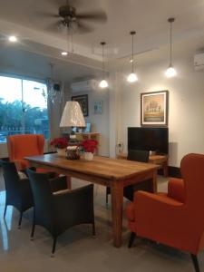 sala de estar con mesa de madera y sillas en Cessna Park Resort and Hotel en Ban Hua Na