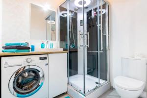 a bathroom with a washing machine and a shower at LEMON Apart in Katowice