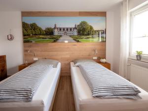 two beds in a room with a painting on the wall at Fewo Papst Nordborchen in Nordborchen