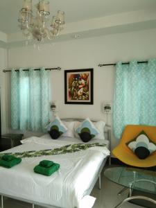 1 Schlafzimmer mit 2 Betten mit blauen Vorhängen und einem Kronleuchter in der Unterkunft Cessna Park Resort and Hotel in Ban Hua Na