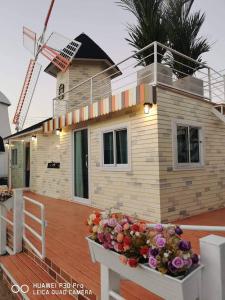 una casa en una terraza con flores delante en ข้าวทุ่งเบ็ญจาโฮมสเตย์, en Ban Hat Phang