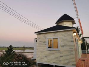 a tiny house with a turret on a deck at ข้าวทุ่งเบ็ญจาโฮมสเตย์ in Ban Hat Phang