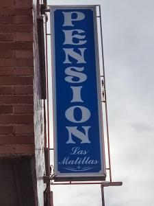 una señal azul colgando del costado de un edificio en Pensión Las Matillas, en Miranda de Ebro